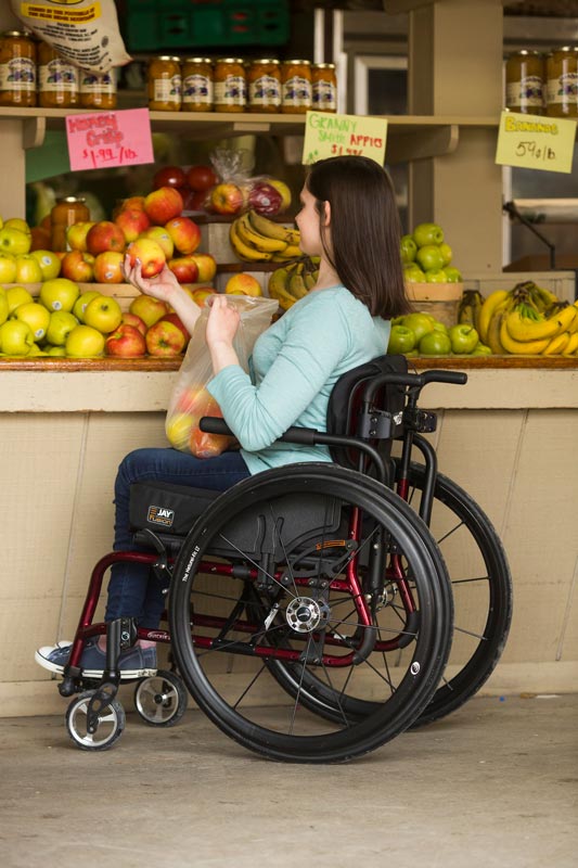 A woman using a wheelchair grocery shopping