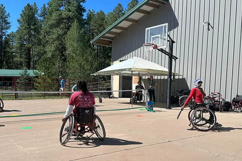 A group of people playing wheelchair tennis together